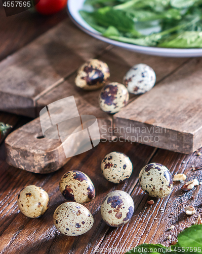 Image of Quail eggs and greens in a plate on a wooden table. Ingredients for Making Healthy Salad