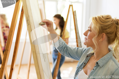 Image of woman with easel drawing at art school studio