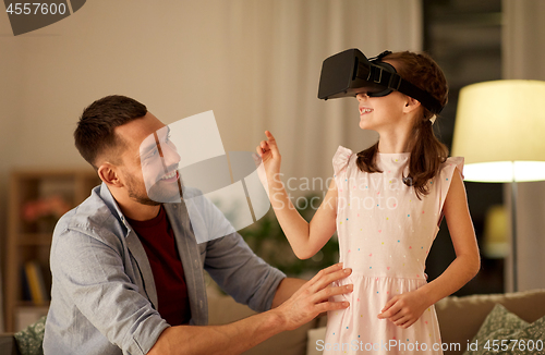 Image of father and daughter in vr glasses playing at home