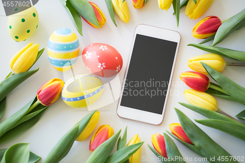 Image of smartphone with easter eggs and tulip flowers