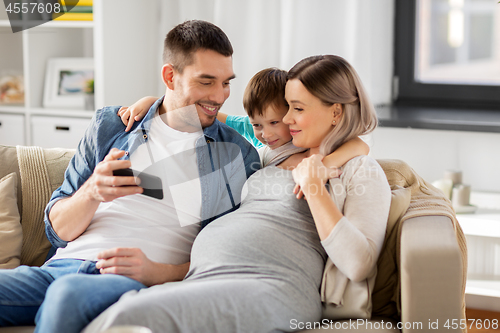 Image of happy family with smartphone at home