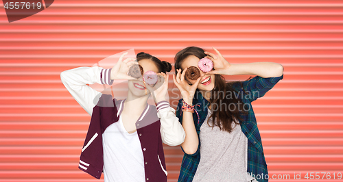 Image of happy teenage girls or friends with donuts on eyes