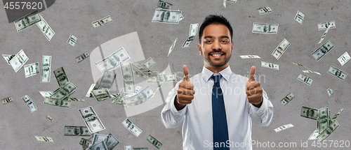 Image of indian businessman showing thumbs up over money