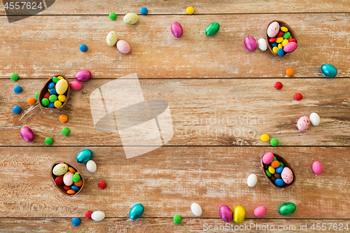 Image of chocolate eggs and candy drops on wooden table