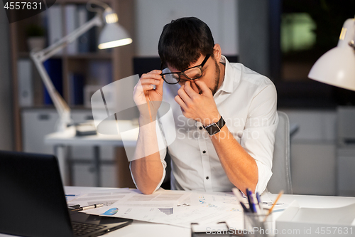 Image of tired businessman working at night office