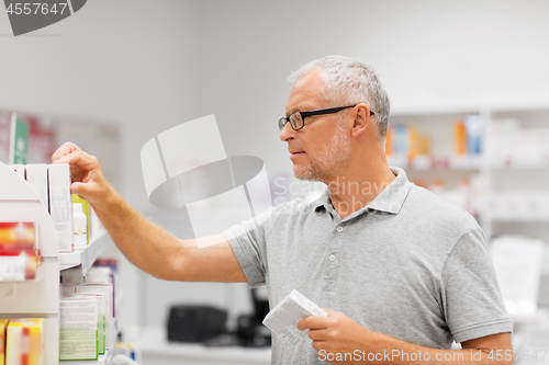 Image of senior male customer with drug at pharmacy