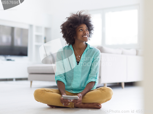 Image of black women using tablet computer on the floor at home