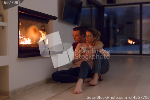 Image of happy couple in front of fireplace