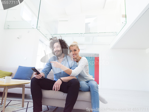 Image of Young couple on the sofa watching television