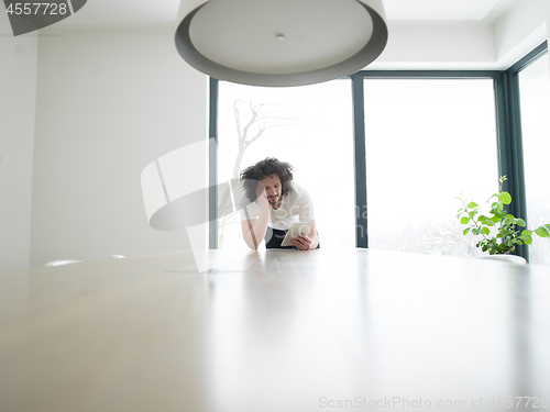 Image of young man using a tablet at home