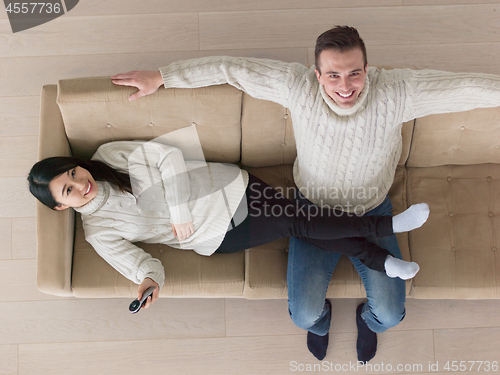 Image of multiethnic couple on the sofa watching television