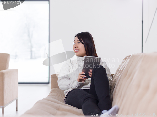 Image of asian woman using Digital Tablet on sofa