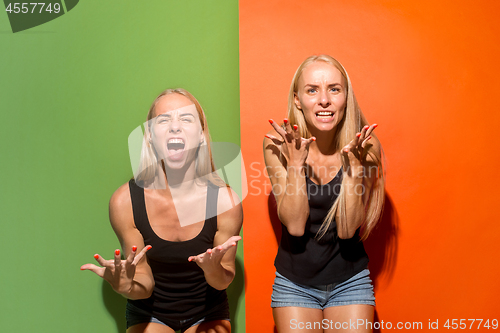 Image of The young emotional angry women screaming on studio background