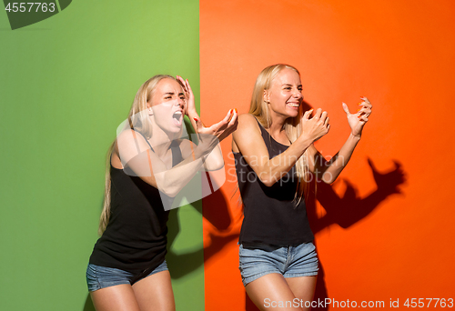 Image of The young emotional angry women screaming on studio background