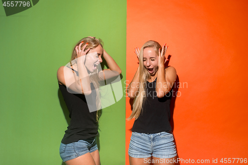 Image of The young emotional angry women screaming on studio background