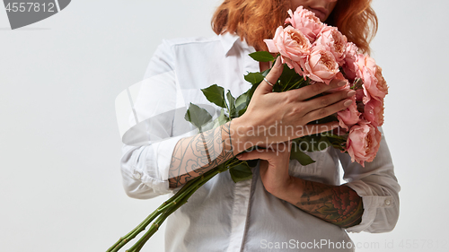 Image of the girl is holding a bouquet of pink roses