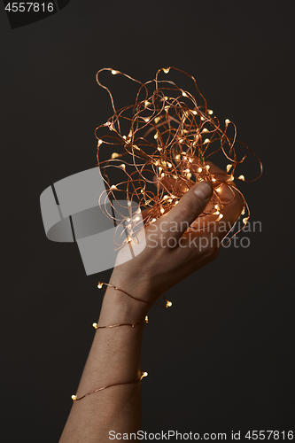 Image of bright christmas lights in woman\'s hands