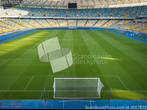 Image of KYIV, UKRAINE - July 19, 2018. Perspective view of NSC Olimpiysky - the inside part with a green football field, tribunes and treadmills.