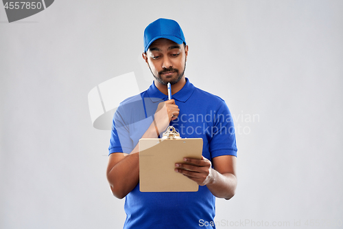 Image of indian delivery man with clipboard in blue