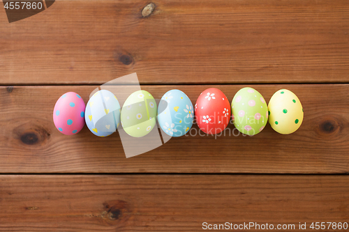 Image of row of colored easter eggs on wooden table