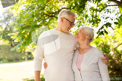 Image of happy senior couple hugging at summer park