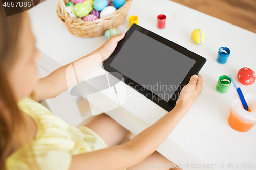 Image of girl with tablet computer, easter eggs and colors