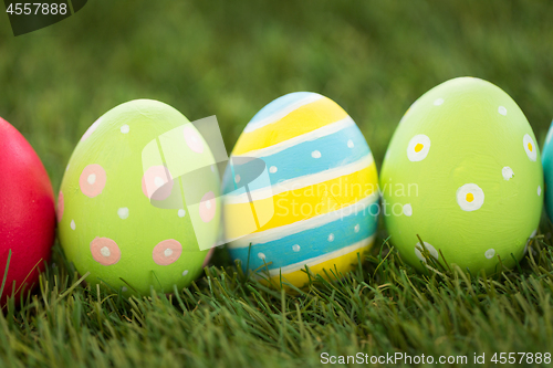 Image of row of colored easter eggs on artificial grass