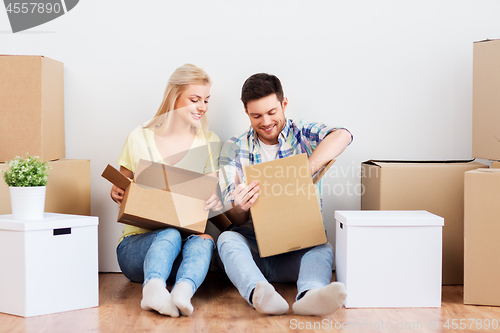 Image of happy couple unpacking boxes at new home