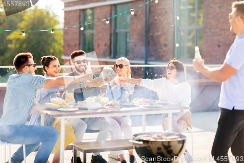 Image of friends toast drinks at bbq party on rooftop