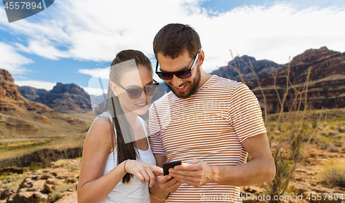 Image of couple with smartphone in summer over grand canyon