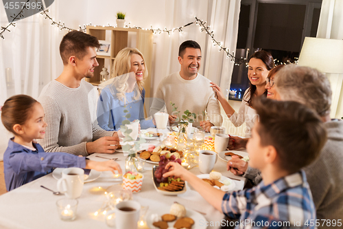 Image of happy family having tea party at home