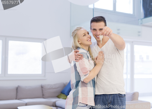 Image of couple showing a keys of their new house