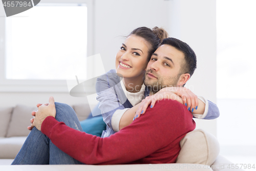 Image of couple hugging and relaxing on sofa