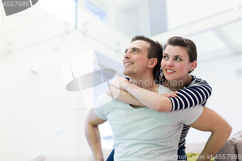 Image of handsome man piggybacking his girlfriend