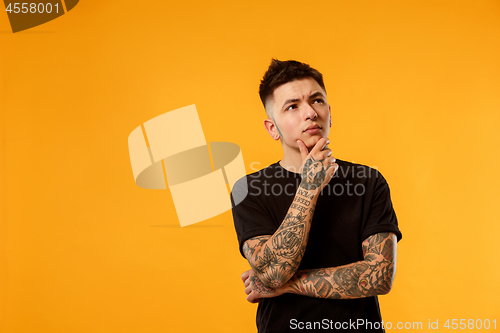 Image of Young serious thoughtful businessman. Doubt concept.