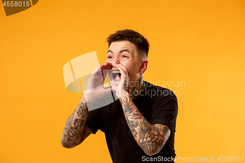 Image of young casual man shouting at studio