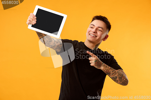 Image of Portrait of a confident casual man showing blank screen of laptop