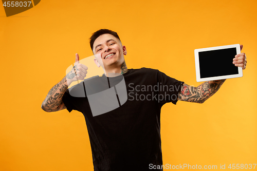 Image of Portrait of a confident casual man showing blank screen of laptop