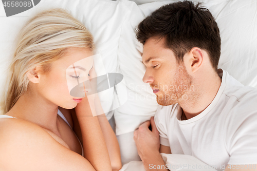 Image of happy couple sleeping in bed at home