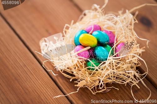 Image of chocolate easter eggs in straw nest on table