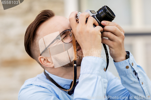 Image of photographer or hipster with film camera outdoors