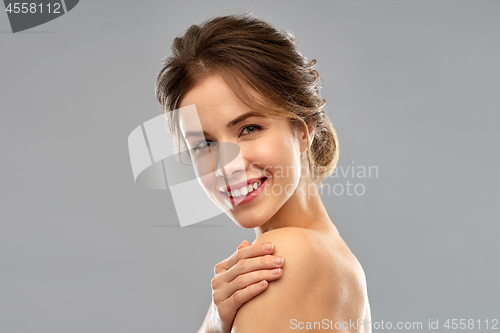 Image of smiling young woman over grey background