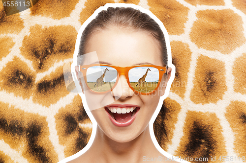 Image of happy teen girl in sunglasses looking at giraffes