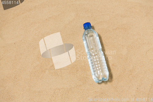 Image of bottle of water on beach sand