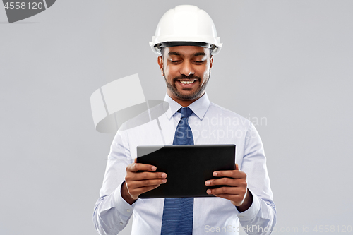 Image of architect or businessman in helmet with tablet pc