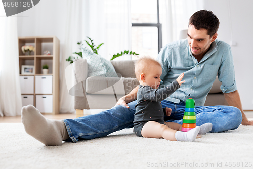 Image of father playing with little baby daughter at home