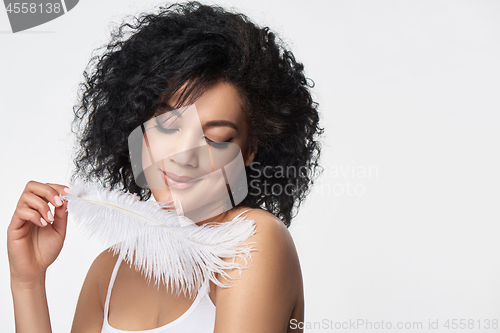 Image of Beautiful mixed race woman holding white ostrich feather