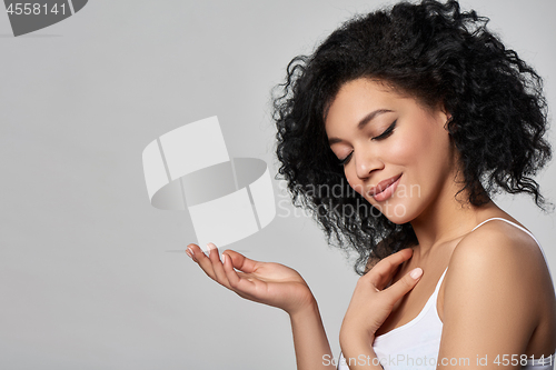 Image of Beautiful mixed race woman with opened palm and closed eyes