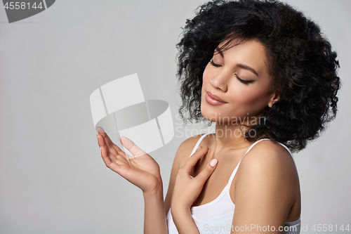Image of Beautiful mixed race woman with opened palm and closed eyes
