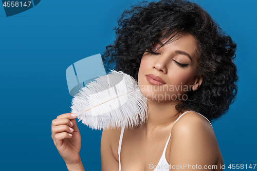 Image of Beautiful mixed race woman holding white ostrich feather